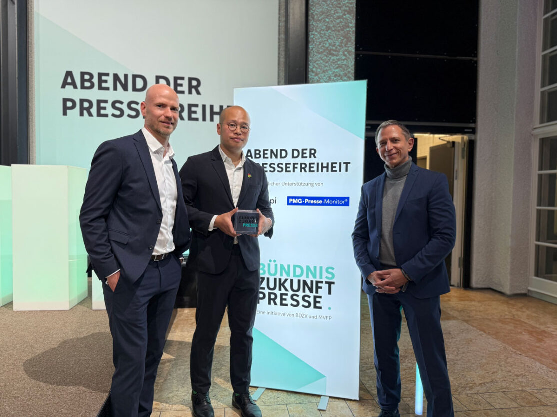 Preis der Pressefreiheit 2026 vergeben. Sebastian Lai (Bildmitte), der Sohn des Verlegers Jimmy Lai, nimmt an Stelle seines in Hongkong inhaftierten Vaters, den Ehrenpreis entgegen. Rechts im Bild: Ingo Kästner, Geschäftsführer der PMG Presse-Monitor. Rechts im Bild: Jan-Sebastian Blender, Leiter Content- und Qualitätsmanagement.