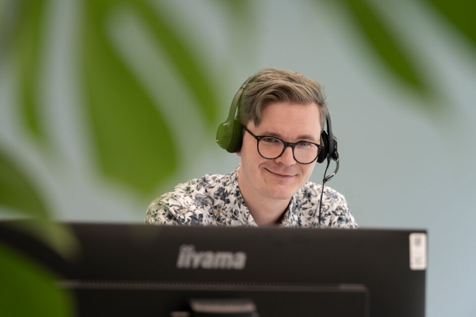 Angestellter mit Headset am Arbeitsplatz