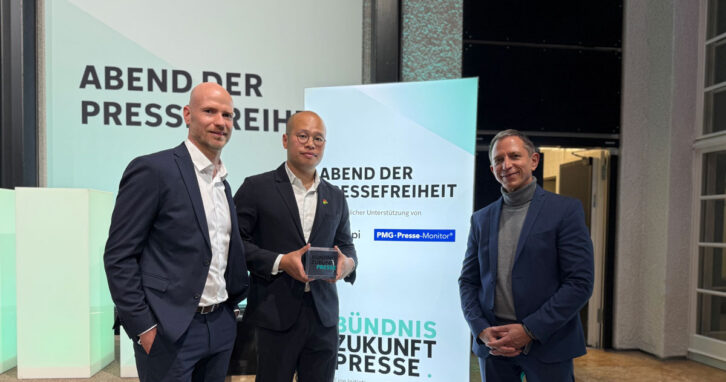 Preis der Pressefreiheit 2026 vergeben. Sebastian Lai (Bildmitte), der Sohn des Verlegers Jimmy Lai, nimmt an Stelle seines in Hongkong inhaftierten Vaters, den Ehrenpreis entgegen. Rechts im Bild: Ingo Kästner, Geschäftsführer der PMG Presse-Monitor. Rechts im Bild: Jan-Sebastian Blender, Leiter Content- und Qualitätsmanagement.